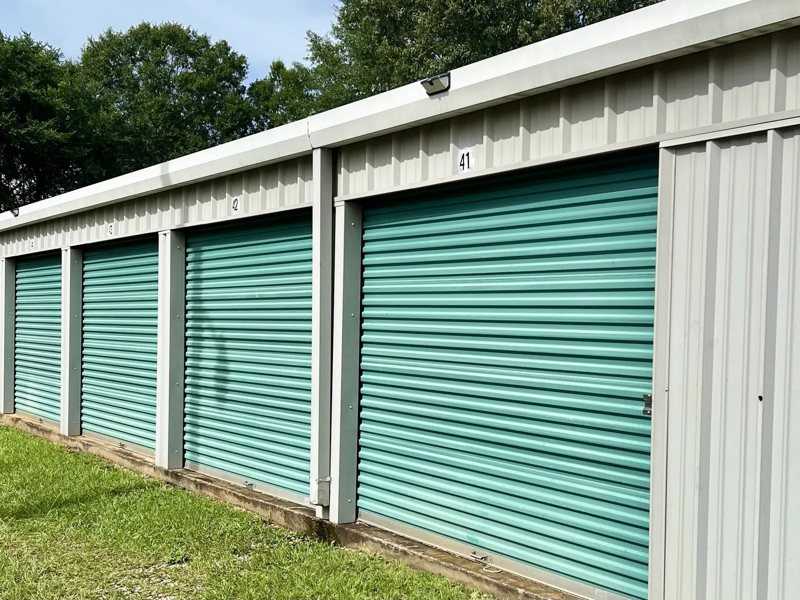 A row of teal roll-up doors at the Lafayette facility with the drive running right up to them